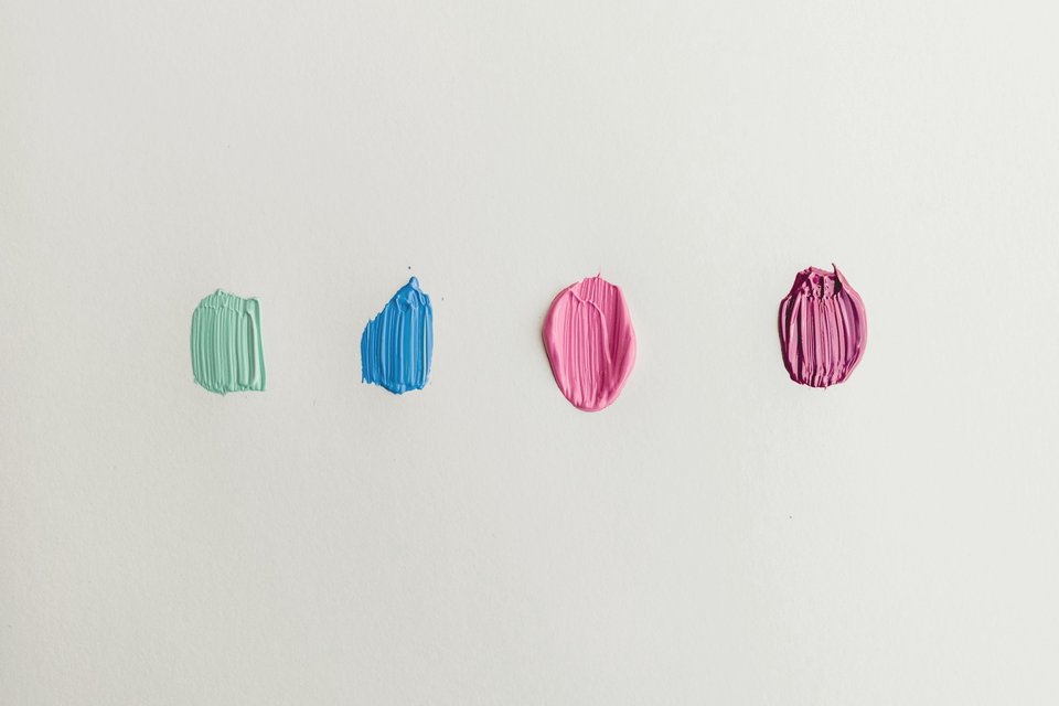 Quatre pots de peinture ouverts, vert, bleu et rose