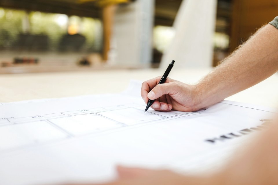 Personne écrivant sur une feuille blanche à un bureau