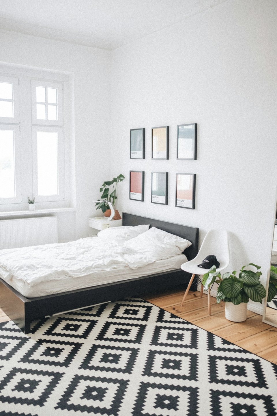 Lit plateforme noir avec linge blanc dans une pièce simple