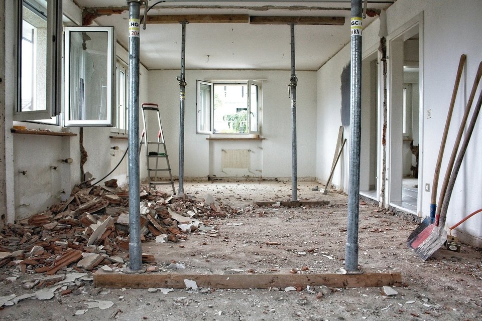 Pièce en travaux avec étais métalliques et outils au sol